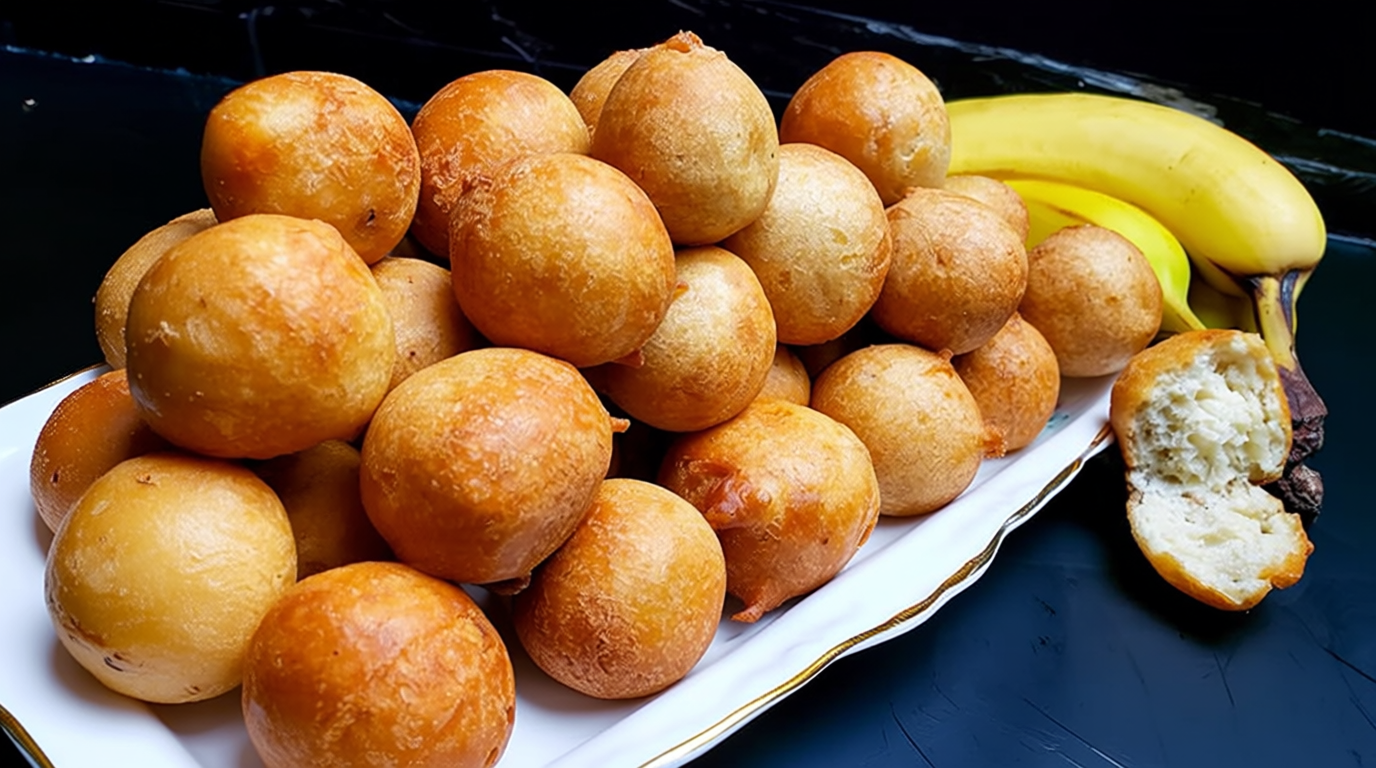 Banana fritters stacked on a plate with powdered sugar